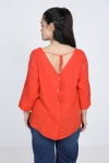 blouse unie boutonnée sur le dos