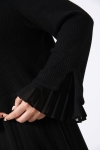 Plain sweater layered over pleated